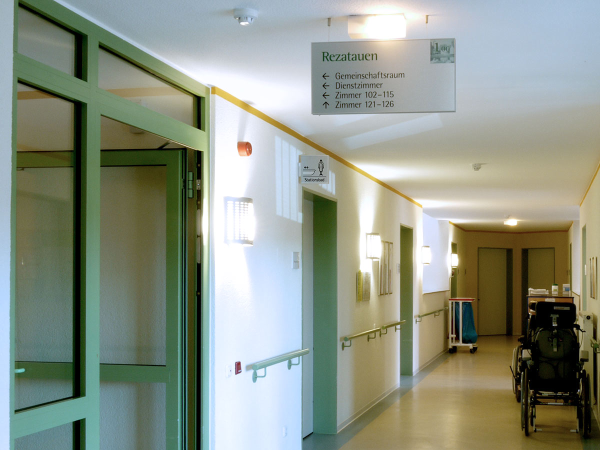 An einer Wegkreuzung hängt ein Wegweiser von der Decke