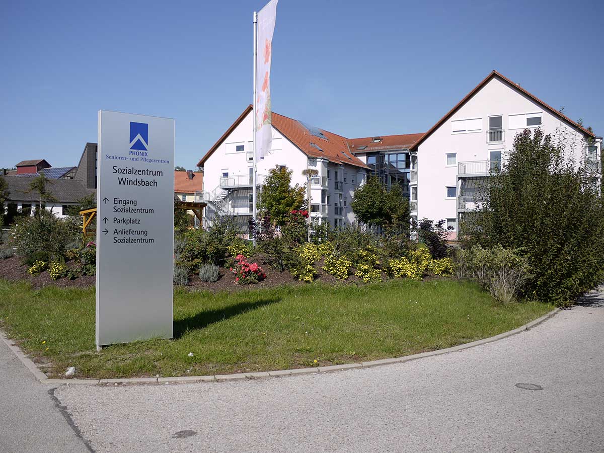 An der Zufahrt zum Gelände steht eine flache Stele